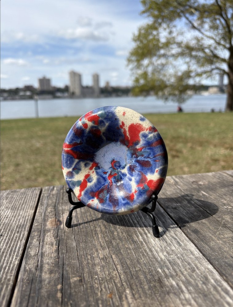 Round ceramic bowl with a blue and red tie-dye glaze pattern